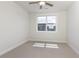 An airy bedroom with neutral carpet, a large window with blinds, and natural light from the window at 323 Concord St, Alpharetta, GA 30009