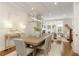 Open-concept dining area with a modern table, decor, and sightlines to the living area with fireplace at 323 Concord St, Alpharetta, GA 30009