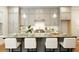 A kitchen showcases a gray island with marble countertop, seating, stylish light fixtures, and modern cabinetry at 323 Concord St, Alpharetta, GA 30009