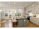Spacious kitchen with a gray island, counter seating, hardwood floors, and stainless appliances at 323 Concord St, Alpharetta, GA 30009
