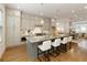A kitchen showcases a gray island with marble countertop, seating, stylish light fixtures, and modern cabinetry at 323 Concord St, Alpharetta, GA 30009