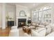 Sun-filled living room with a fireplace, neutral decor, and large windows offering views of the property at 323 Concord St, Alpharetta, GA 30009