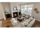 Open-concept living room featuring a fireplace, large windows, hardwood floors, and modern decorations at 323 Concord St, Alpharetta, GA 30009