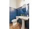 Stylish powder room with navy wainscoting, pedestal sink, and round mirror at 323 Concord St, Alpharetta, GA 30009