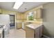 A quaint kitchen featuring warm toned cabinets, a window with a view, and tile flooring at 5245 Olde Mill Rd, Woodstock, GA 30188