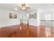 Spacious living room with gleaming hardwood floors, a ceiling fan, and access to the upper level at 6213 Indian Wood Cir, Mableton, GA 30126
