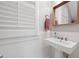 Bathroom featuring pedestal sink, wainscotting, white trim, and a wood-framed mirror at 630 John Wesley Dobbs Ne Ave, Atlanta, GA 30312