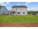 A spacious backyard featuring a well-maintained lawn and a covered patio seating area at 707 Mirror Lake Parkway Way, Villa Rica, GA 30180