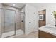Modern bathroom featuring a glass enclosed shower with tiled walls, a white sink, and a closed door at 707 Mirror Lake Parkway Way, Villa Rica, GA 30180