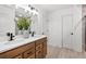 Bright bathroom with double sinks, wood cabinets, and a view of the shower and adjacent rooms at 707 Mirror Lake Parkway Way, Villa Rica, GA 30180