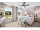 Floral themed bedroom featuring large windows, light pink walls, and a modern glass desk at 707 Mirror Lake Parkway Way, Villa Rica, GA 30180