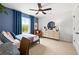 A cozy bedroom with baseball themed decor, blue walls, and natural light streaming through the window at 707 Mirror Lake Parkway Way, Villa Rica, GA 30180