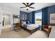 A charming bedroom with baseball decor, blue walls, carpet floors, and a matching ceiling fan at 707 Mirror Lake Parkway Way, Villa Rica, GA 30180