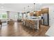 Open-concept kitchen features a large island with seating, stainless steel appliances, and wood floors at 707 Mirror Lake Parkway Way, Villa Rica, GA 30180