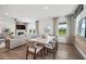 Open-concept dining and living area with a fireplace, plenty of natural light, and modern decor at 707 Mirror Lake Parkway Way, Villa Rica, GA 30180