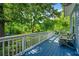 Inviting back porch featuring blue flooring, comfortable seating, and views of the lush green yard with mature trees at 7550 Fielder Rd, Jonesboro, GA 30236