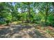 Backyard retreat features a wooden fence, mature trees, and a bench at 7550 Fielder Rd, Jonesboro, GA 30236