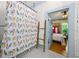 A renovated bathroom features a colorful shower curtain, ladder for towels and tiled floor at 7550 Fielder Rd, Jonesboro, GA 30236