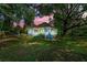 Charming two-story home with a lush lawn and mature trees is lit by a colorful sunset at 7550 Fielder Rd, Jonesboro, GA 30236