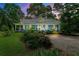 Charming blue home with a metal roof, inviting front porch, and lush landscaping at dusk at 7550 Fielder Rd, Jonesboro, GA 30236