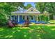 Charming blue home featuring a metal roof, a welcoming front porch, and lush landscaping at 7550 Fielder Rd, Jonesboro, GA 30236