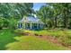 Charming blue two-story home with a metal roof, inviting front porch, and a lush green lawn at 7550 Fielder Rd, Jonesboro, GA 30236