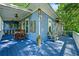 Bright blue porch features wood floors, a wooden bar, and views of the wooded lawn at 7550 Fielder Rd, Jonesboro, GA 30236
