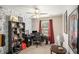 This bedroom features decorative wallpaper, a ceiling fan, and a dark wood bookshelf alongside a desk area at 10312 Waterford Ne Rd, Covington, GA 30014
