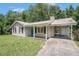 Charming one-story home with a metal roof, teal door, and well-maintained front yard at 10312 Waterford Ne Rd, Covington, GA 30014