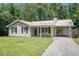 Charming one-story home with a metal roof, teal door, and well-maintained front yard at 10312 Waterford Ne Rd, Covington, GA 30014