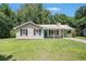 Charming one-story home with a metal roof, teal door, and well-maintained front yard at 10312 Waterford Ne Rd, Covington, GA 30014