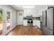 Bright kitchen features stainless steel appliances, white cabinetry, hardwood floors, and access to the deck at 10312 Waterford Ne Rd, Covington, GA 30014