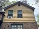 The home's exterior combines yellow siding with a brick foundation, offering a rustic yet sturdy appeal at 2513 Rockwood Way, Stone Mountain, GA 30087