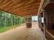 Covered porch with wood floors and view of lush greenery from an unfinished home at 3435 Dr Bramblett Rd, Cumming, GA 30028