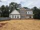 New home features brick and siding, black trimmed windows, and a covered porch at 3435 Dr Bramblett Rd, Cumming, GA 30028