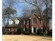 Traditional brick home featuring a large front yard, arched window, and a welcoming entrance at 3580 Treeline Ne Pass, Roswell, GA 30075