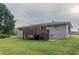 View of the backyard featuring a deck, a well-manicured lawn, and a brick house exterior at 2290 Pope Rd, Douglasville, GA 30135