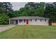 Charming single-story home with a well-maintained lawn, a bright red front door and convenient carport at 2290 Pope Rd, Douglasville, GA 30135