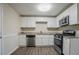 The remodeled kitchen features white cabinets, stainless appliances and a black gas range at 2290 Pope Rd, Douglasville, GA 30135