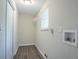 Bright laundry room featuring wood-look flooring, a window and a wall mounted shelf at 2290 Pope Rd, Douglasville, GA 30135