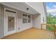 Covered back porch with wood floor, white trim, and a view of the landscaped backyard at 2499 Barrett Preserve Sw Ct, Marietta, GA 30064