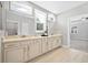 Bright bathroom featuring double sinks, quartz counters, and a tile floor at 2499 Barrett Preserve Sw Ct, Marietta, GA 30064