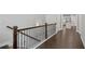 Hallway with wrought iron railing and a glimpse of a kitchen and living area at 2499 Barrett Preserve Sw Ct, Marietta, GA 30064