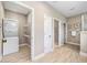 Convenient laundry room featuring a stackable washer and dryer with shelving for storage at 2499 Barrett Preserve Sw Ct, Marietta, GA 30064