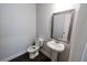 Half-bath with pedestal sink, decorative mirror, and modern fixtures at 2692 Pearl Ridge Trce, Buford, GA 30519
