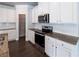 Modern kitchen featuring white cabinets, stainless steel appliances, granite countertops, and tile backsplash at 2692 Pearl Ridge Trce, Buford, GA 30519