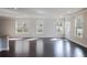 Bright and airy living room with dark hardwood floors, three windows, and neutral paint at 2692 Pearl Ridge Trce, Buford, GA 30519