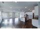 Open-concept living room with a kitchen island, stainless steel appliances, dark hardwood floors, and natural light at 2692 Pearl Ridge Trce, Buford, GA 30519