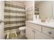 Well-lit bathroom featuring a shower-tub with a patterned curtain and storage shelves at 320 Conley Ave, Hampton, GA 30228
