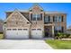 Charming two-story brick home featuring a manicured lawn and a convenient two-car garage at 320 Conley Ave, Hampton, GA 30228